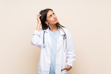 Young doctor woman over isolated background having doubts and with confuse face expression - obrazy, fototapety, plakaty