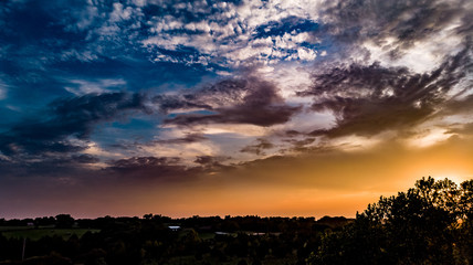Golden hour sunset over the prairie with clouds and blue sky