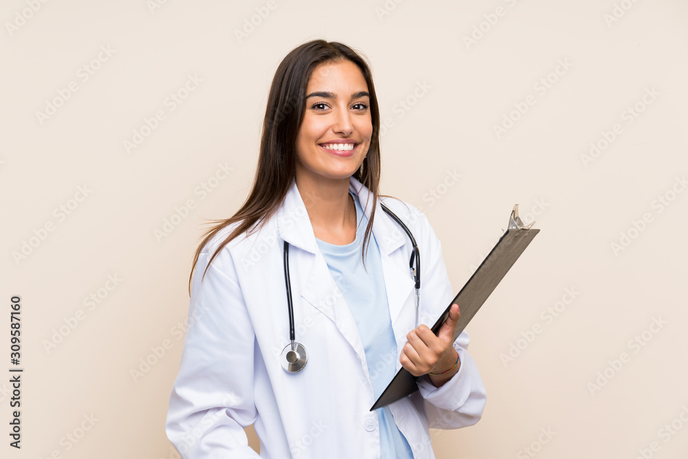 Wall mural young doctor woman over isolated background holding a folder