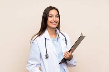 Young doctor woman over isolated background holding a folder