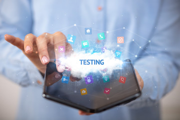 Businessman holding a foldable smartphone with TESTING inscription, technology concept