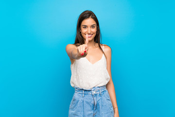 Young woman over isolated blue background showing and lifting a finger