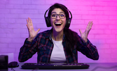 Happy esport female gamer playing online game on computer © Prostock-studio
