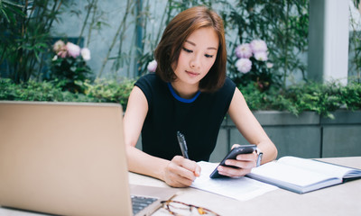 Asian female freelancer handwriting on paper