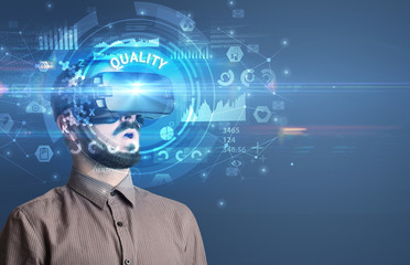 Businessman looking through Virtual Reality glasses with QUALITY inscription, innovative technology concept