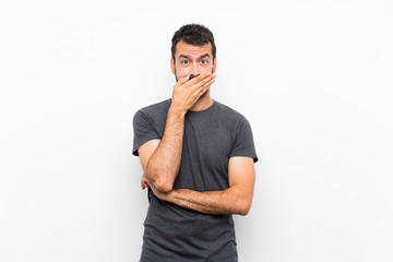 Young handsome man over isolated white background covering mouth with hands