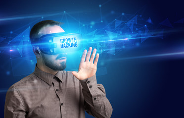 Businessman looking through Virtual Reality glasses with GROWTH HACKING inscription, cyber security concept