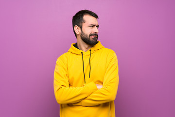 Handsome man with yellow sweatshirt with confuse face expression