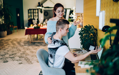 Cheerful couple in front of laptop at home