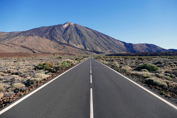 Straight empty road with volcano Teide in the background in Teide National Park, Tenerife, Spain.