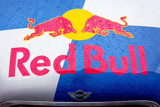 Red Bull mini cooper publicity car logo. fancy car tuning used for promotion. wet advertisement vehicle after the rain