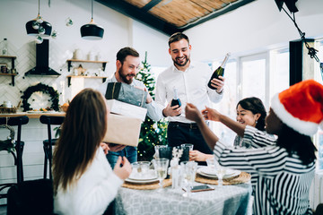 Cheerful men carrying bottles of champagne to table