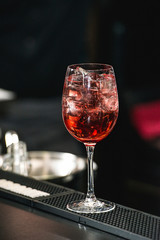 bartender making refreshing pink coctail with a rose on top isolated on a bar background
