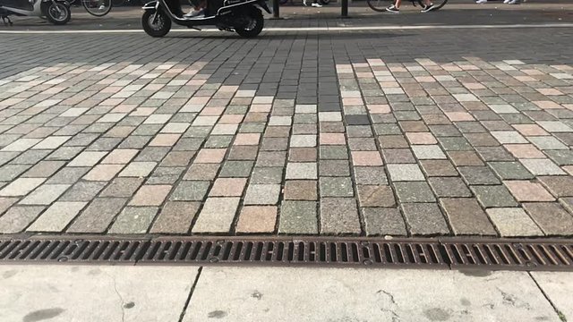 slow motion of a scooter driving by filmed at a low angle