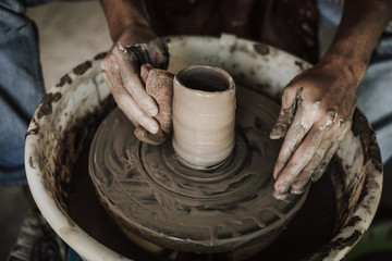 Hands of craftsman artist working on pottery wheel.Selective Focus .
