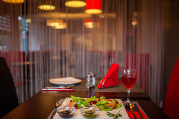 Served for holiday banquet restaurant table with dishes, snack, salads, cutlery, wine and water glasses. European food in a restaurant setting. Table set for an event party. catering