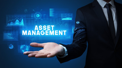 Hand of Businessman holding ASSET MANAGEMENT inscription, business success concept