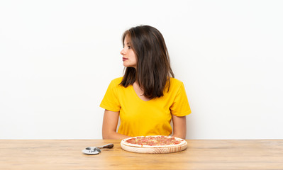 Caucasian girl with a pizza looking side