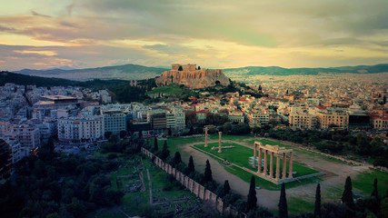 Obraz premium Aerial drone photo of iconic ruins of Temple of Zeus in Athens historic centre at dusk with beautiful sky and colours and Syggrou avenue at the background, Attica, Greece