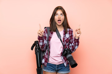 Young photographer girl over isolated pink background pointing with the index finger a great idea