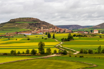 Scenic Castrojeriz springtime view on the Way of St. James, Camino de Santiago in Castile and Leon, Spain under overcast May sky