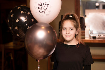 Naklejka premium Young girl with gel balls having fun celebrating birthday in cafe