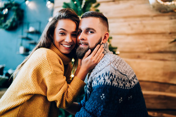 Laughing couple nestling in cozy sweaters