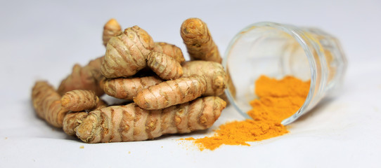Turmeric root and powder on white background