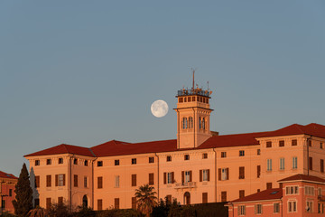 Full moon setting at sunrise