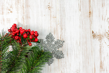Christmas composition background decoration with fir pine tree branches snowflake and red berries on wooden white background. Flat lay, top view, copy space