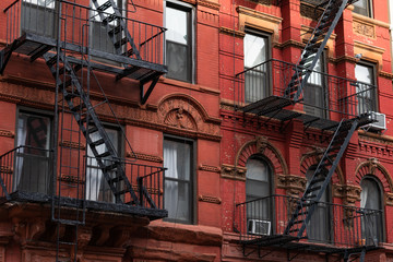 Fototapeta na wymiar Colorful Old Brick Buildings in the East Village of New York City with Fire Escapes 