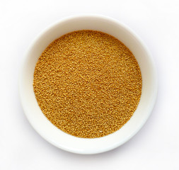 Amaranth raw seeds in white ceramic bowl isolated on white background. Bowl of healthy amaranth seeds top view, selective focus