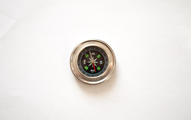 Compass in a metal frame on a white background. View from above.