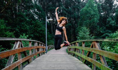 Fototapeta na wymiar Happy athlete woman taking a leap outdoors