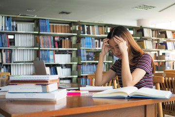 Beautiful Asian students feel stressed by reading books for university entrance exams or tired of...