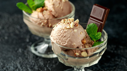 Chocolate Ice Cream with dark chocolate bars and hazelnuts in a glass bowl