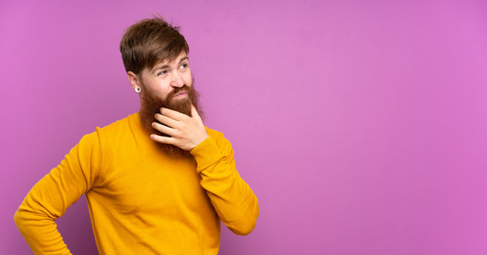Redhead man with long beard over isolated purple background thinking