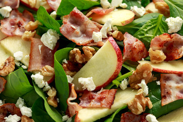 Bacon, Apple Salad with spinach, walnuts and feta cheese. on wooden table. healthy food.