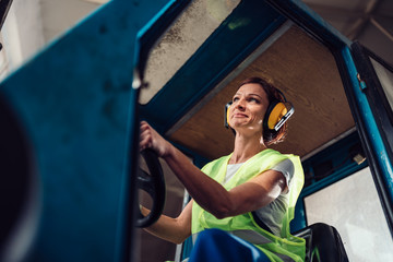 Woman forklift operator driving vehicle
