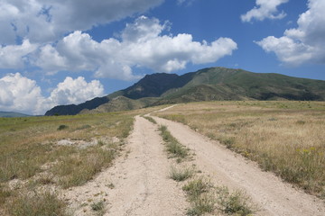 mountain road with blue sky and clouds