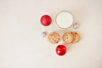 Chocolate chip cookies with a glass of milk on a light gray background and a wooden wall. Copy space. Banner.