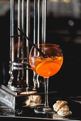 glass of refreshing orange alcoholic cocktail on a table in the bar