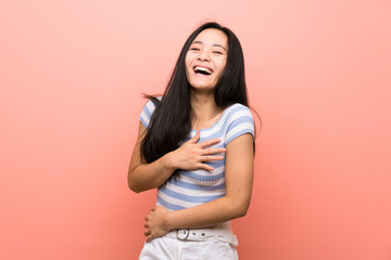 Obraz premium Teenager asian girl over isolated pink background smiling a lot