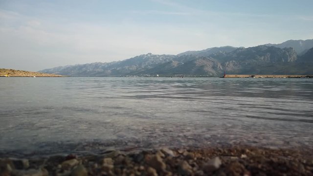 Water level view of warm, clear bay with swimmers on a sunny afternoon