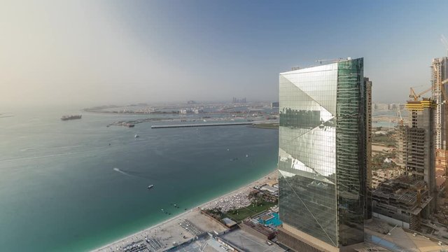 Modern skyscrapers in Jumeirah beach residence in Dubai, JBR aerial timelapse with palm Jumeirah on a background during sunset