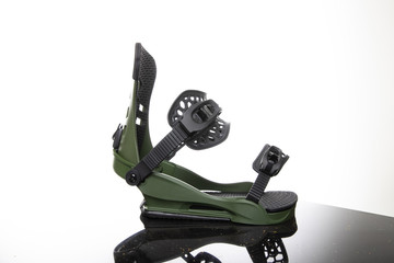 Snowboard fastenings boots stand on a glass surface on a white background