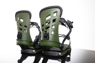Snowboard fastenings boots stand on a glass surface on a white background