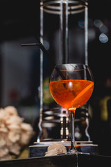 glass of refreshing orange alcoholic cocktail on a table in the bar