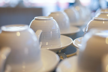 Coffee or tea ceramic cup stacked on buffet table that ready to serve to participant / attendees in seminar or cafe