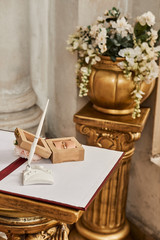 On a beautiful stand are two wedding rings in a wooden box and decorated with flowers